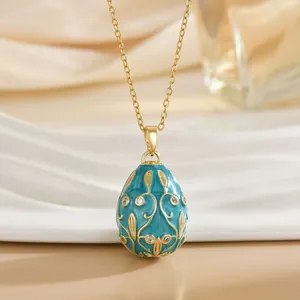 Detailed close-up of Russian style egg pendant with blue enamel and gold vine patterns