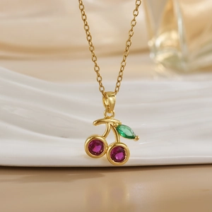 Detailed close-up of cherry pendant necklace with purple stones and green crystal leaf