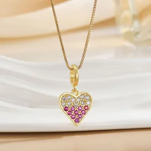 Macro detail of gold-plated heart necklace with sparkling pink and white cubic zirconia