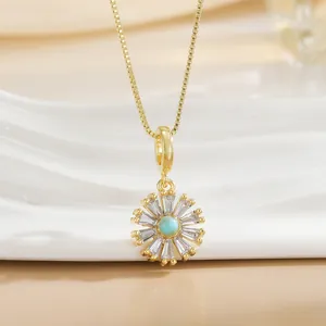 Detail of sunflower pendant with turquoise center and baguette zircon petals on gold chain