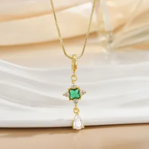 Detailed macro view of gold plated necklace with green emerald and zirconia stones