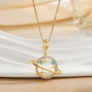 Detail of gold plated Saturn pendant necklace with blue beads and zircon crystals