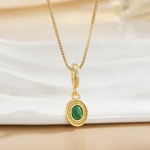 Close-up of gold-plated box chain necklace with green malachite pendant and zircon details