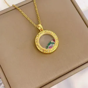 Gouden ronde glazen medaillon ketting met kleurrijke edelstenen op juwelendoos