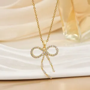Elegante goldene Schleifen-Halskette mit Zirkonia-Anhängern auf Satin-Hintergrund