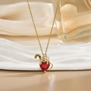 Détail d'un collier doré avec pendentif cœur rouge et accents de zircons colorés