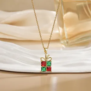 Détail macro du pendentif boîte cadeau de Noël avec pierres rouges et vertes