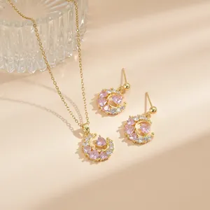 Detailansicht von Halskette und Ohrringen mit Halbmond und rosa Herz-Edelsteinen