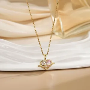 Detailed macro view of heart-shaped planet pendant with pink zircon on ceramic tray