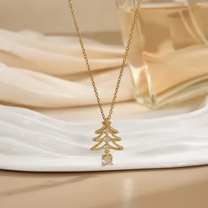 Collier avec pendentif sapin de Noël doré et zircons brillants sur un fond de tissu satiné