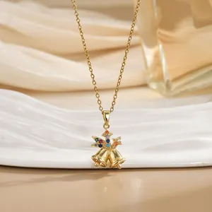 Détail du pendentif cloches de Noël dorées avec pierres précieuses colorées sur chaîne fine