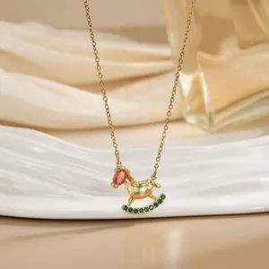 Détail du collier cheval à bascule avec pierre orange et zircons verts étincelants
