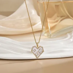 Close-up of heart pendant necklace with pink stones and sparkling gold chain details