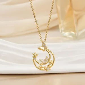 Detailed close-up of a gold-plated moon and butterfly pendant with sparkling zircons