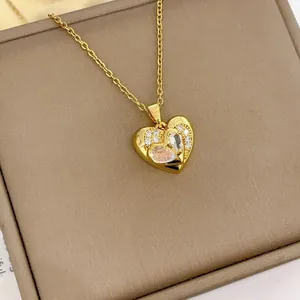 Élégant collier pendentif coeur doré avec accents de zircon sur boîte à bijoux marron