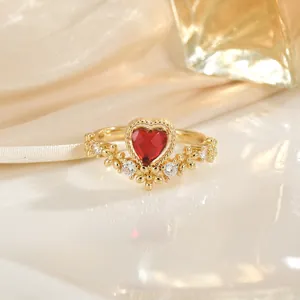 Vue macro de la bague en or avec rubis en forme de cœur et zircons blancs étincelants