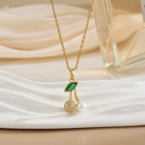 Macro detail of cherry pendant with pearl and micro-pave stones on golden chain