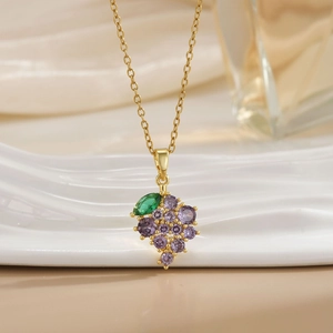 Detailed close-up of gold grape pendant necklace with purple and green zircon stones