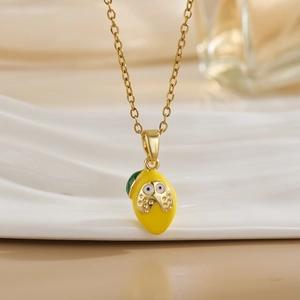 Detail of a handmade lemon pendant necklace with yellow enamel and a cute face design