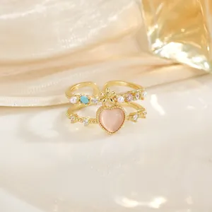 Bague double dorée élégante avec pierre œil de chat rose et perles bleues