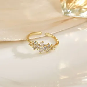 Bague fleur dorée ajustable élégante avec cristaux de zircon sur fond de soie
