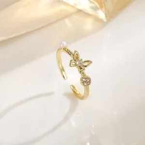 Verstelbare gouden ring met een fonkelende zirkoon vlinder en witte parel detail