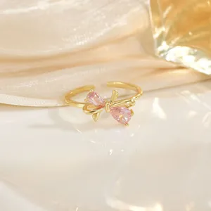 Bague ouverte nœud plaqué or 18K avec zircon rose en forme de poire sur fond de soie