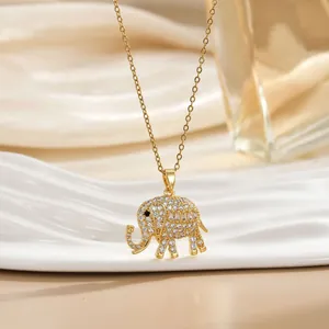 Elegant gold elephant pendant necklace with white crystals on a soft satin background