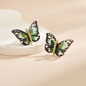 Gros plan détaillé de boucles d'oreilles papillon avec des ailes vertes et cristaux