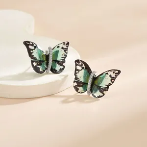 Détail des boucles d'oreilles papillon avec ailes dégradées vertes et pierres de zircone
