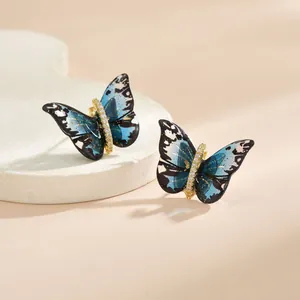 Détail macro des boucles d'oreilles papillon avec ailes bleues et zircons brillants