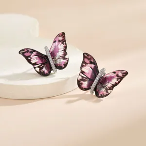 Détail des boucles d'oreilles papillon de luxe avec motifs violets et diamants brillants