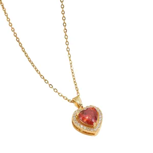 Makroaufnahme einer goldfarbenen Herzkette mit rotem Zirkon und weißem Diamant-Halo