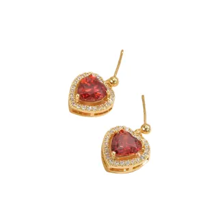 Detail von Herz-Ohrringen mit rotem Zirkonia, Goldfassung und kleinen weißen Steinchen