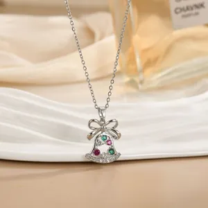 Dettaglio macro di una collana con ciondolo a campana d'argento e zirconi colorati