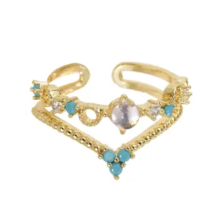 Elegante verstelbare gouden ring met blauwe kralen en zirkoonstenen in dubbel V-vormig ontwerp