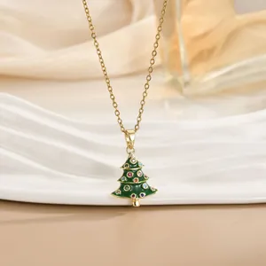 Dettaglio macro della collana dorata con ciondolo albero di Natale verde e cristalli colorati