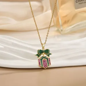 Dettaglio della collana dorata con ciondolo a scatola regalo e zirconi colorati