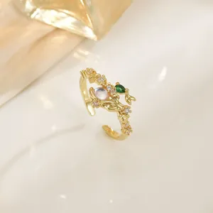 Detail of gold branch ring featuring moonstone, green zircon, and pavé diamonds