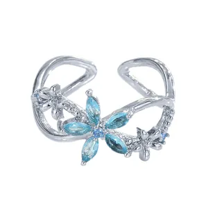 Eleganter silberner offener Ring mit hellblauer Edelsteinblüte und feinem Schleifendesign