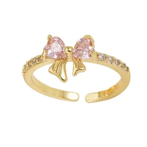 Elegant adjustable ring with pink heart stones forming a bow shape and pavé zircon accents