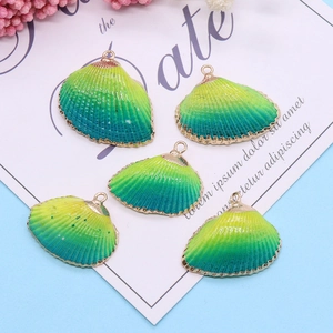 Cinq pendentifs coquillages dégradé jaune-vert bordés d'or pour la création de bijoux