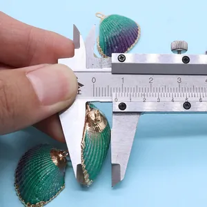 Mesure d'un pendentif coquillage dégradé vert avec bordure dorée à l'aide d'un pied à coulisse
