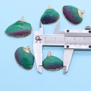 Détail de la mesure d'un pendentif en coquillage vert avec des bordures dorées polies