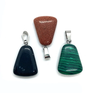 Macro detail of trapezoid-shaped gemstone pendants in obsidian goldstone and malachite