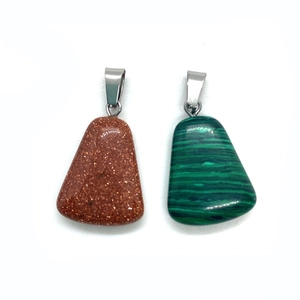 Detailed macro view of trapezoid malachite and goldstone mineral pendants with silver clips