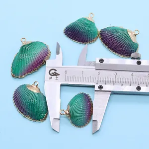 Détail montrant la mesure de 25mm des pendentifs coquillage vert-violet à bords dorés