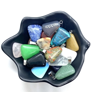 Polished triangular natural stone pendants in a Hamsa dish for jewelry making