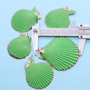 Détail de pendentifs en forme de coquille colorée avec bord doré et mesure précise