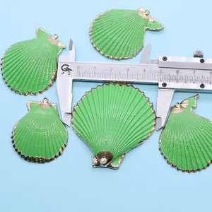 Pendentif coquille verte bordé d'or montré sur pied à coulisse pour la mesure